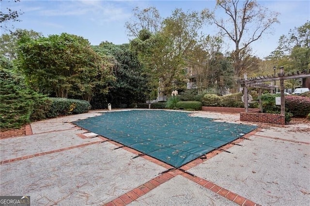 view of swimming pool featuring a pergola, a patio area, and a covered pool