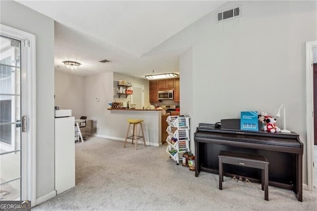 living area featuring visible vents, baseboards, vaulted ceiling, and light carpet