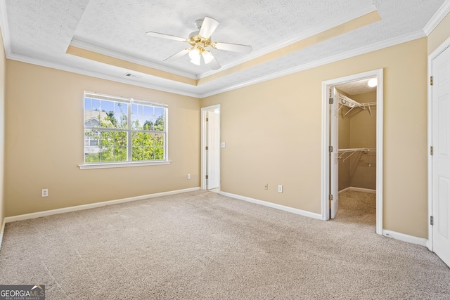 1016 Borrington Ln, Stockbridge, GA 30281 - unfurnished bedroom with a raised ceiling, ornamental molding, a textured ceiling, carpet flooring, and a spacious closet