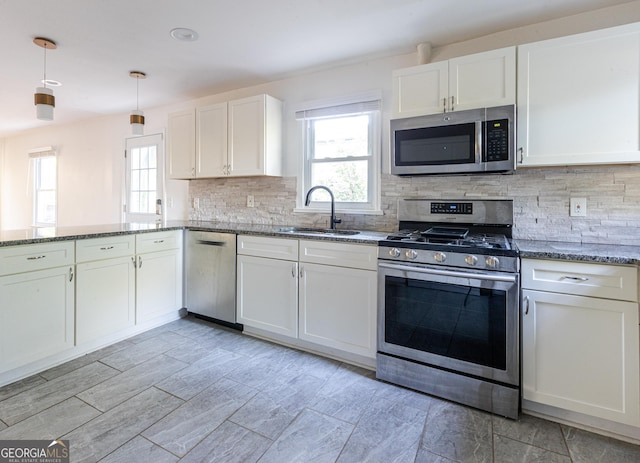 kitchen with a wealth of natural light, white cabinetry, stainless steel appliances, and a sink