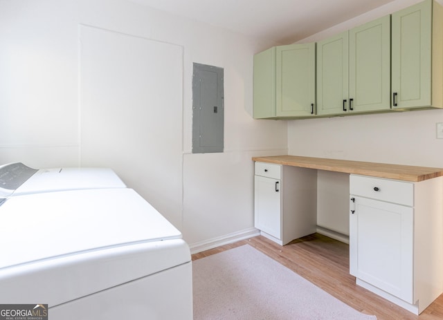 laundry area with washing machine and dryer, light wood-style floors, electric panel, and cabinet space