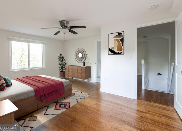 bedroom with wood finished floors, a ceiling fan, and baseboards