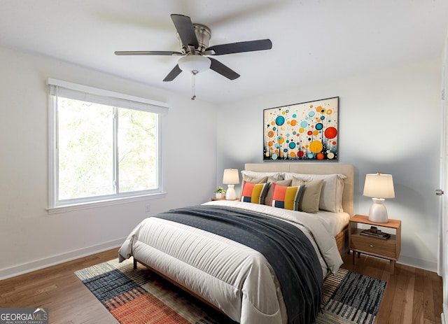 bedroom featuring ceiling fan, baseboards, and wood finished floors