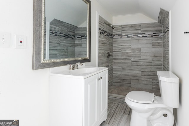 full bathroom with vanity, toilet, and tiled shower