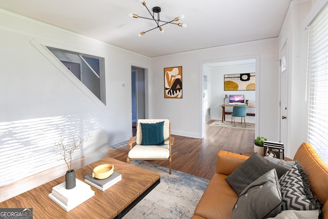 living room featuring visible vents, baseboards, wood finished floors, and a notable chandelier