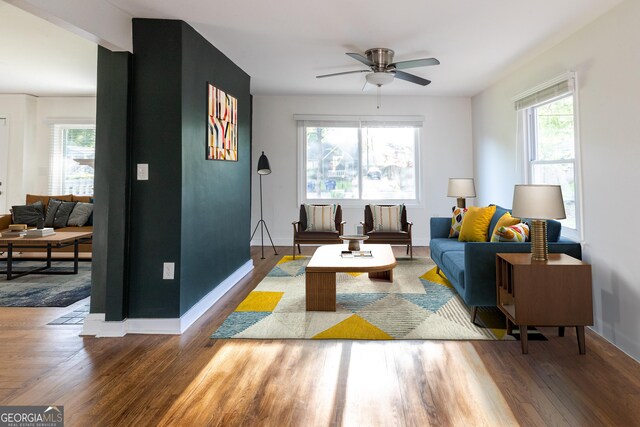 living room with a wealth of natural light, a ceiling fan, and wood finished floors
