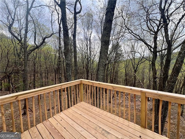 wooden terrace featuring a view of trees