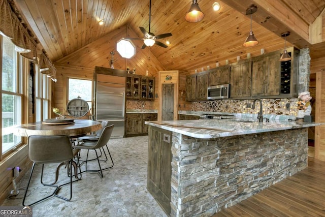 kitchen featuring a wealth of natural light, wooden ceiling, and stainless steel appliances