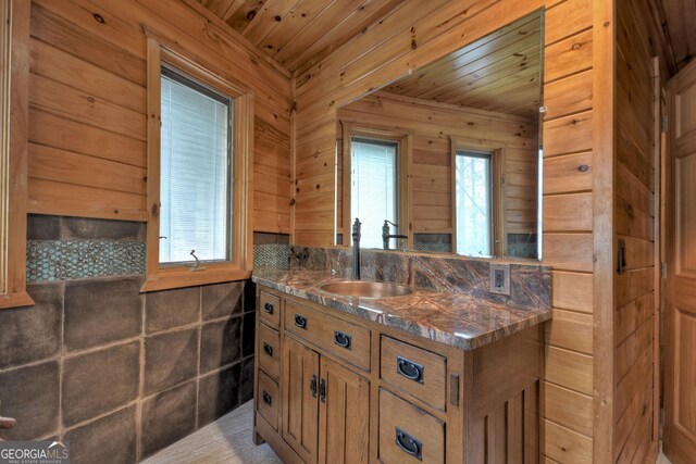 full bath featuring a freestanding bath, vanity, tile walls, and wooden ceiling