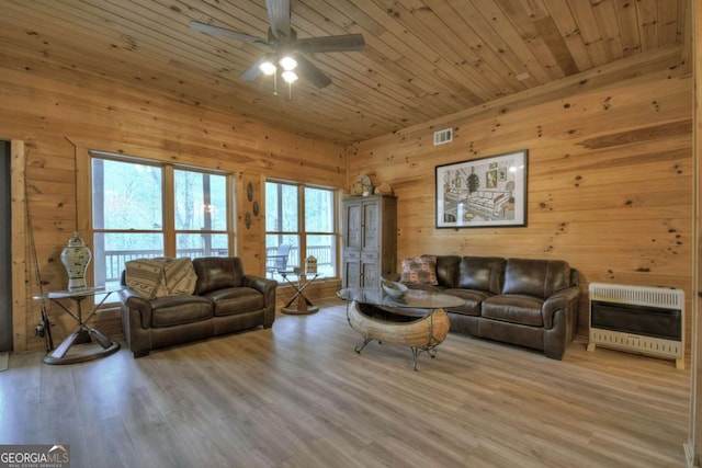 living area with a wealth of natural light, heating unit, and wood ceiling