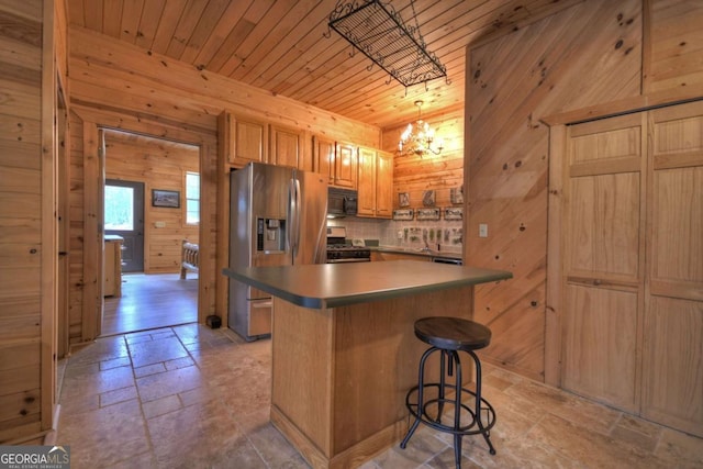 kitchen featuring wooden walls, stone tile flooring, appliances with stainless steel finishes, and wood ceiling