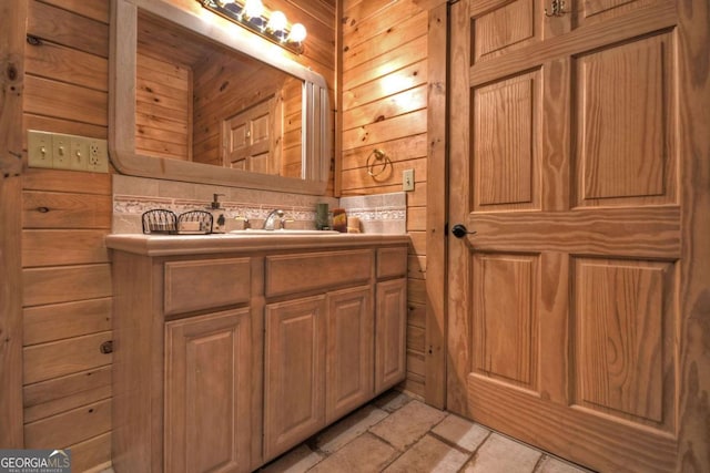bathroom with stone tile floors and vanity