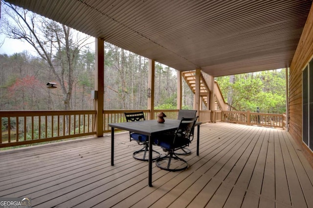 wooden terrace with stairs and outdoor dining area