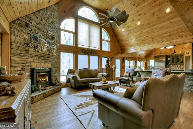 living area featuring light wood-style flooring, wooden ceiling, and a wealth of natural light
