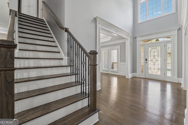 foyer entrance with stairs, a towering ceiling, and a wealth of natural light