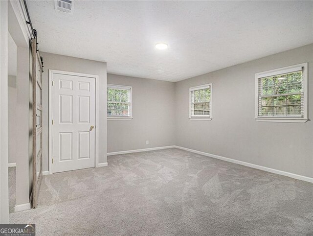 2544 Peyton Woods Trl SW, Atlanta, GA 30311 - unfurnished room featuring a barn door, carpet, and a textured ceiling
