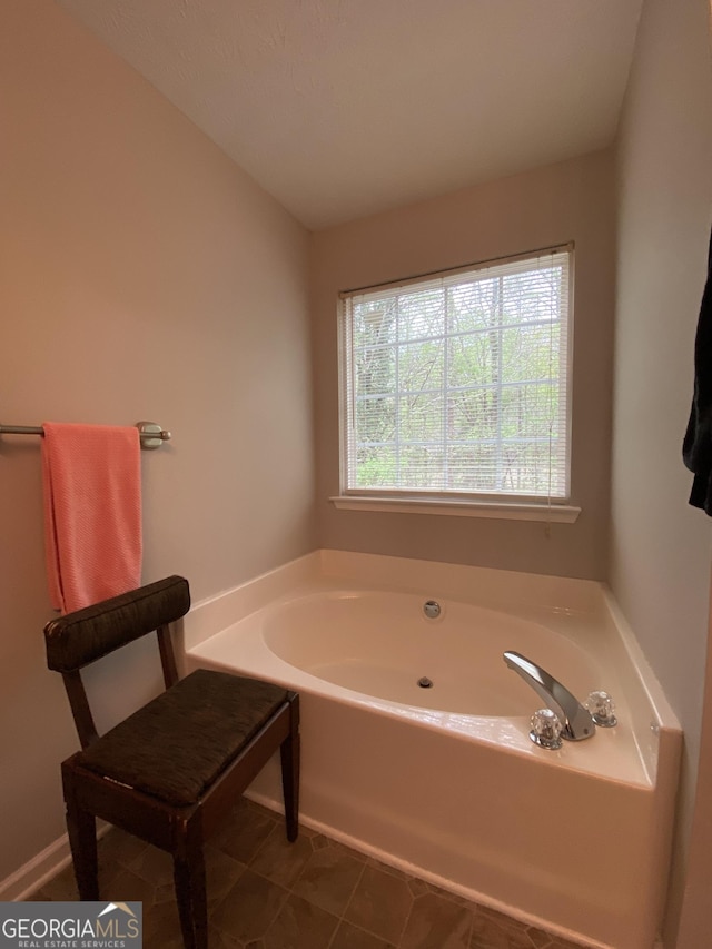 full bathroom featuring tile patterned flooring, a bath, and lofted ceiling