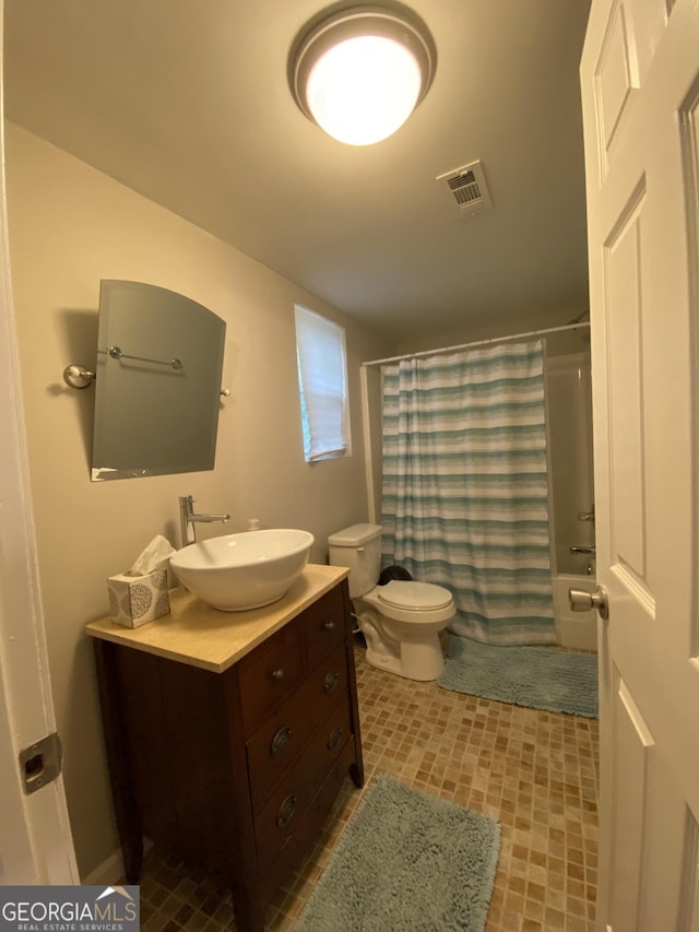 full bathroom featuring shower / tub combo, vanity, visible vents, and toilet