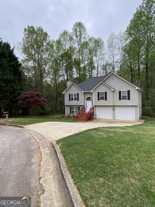 split foyer home featuring a garage, driveway, and a front lawn