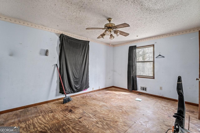 empty room featuring a textured ceiling, ceiling fan, baseboards, and visible vents