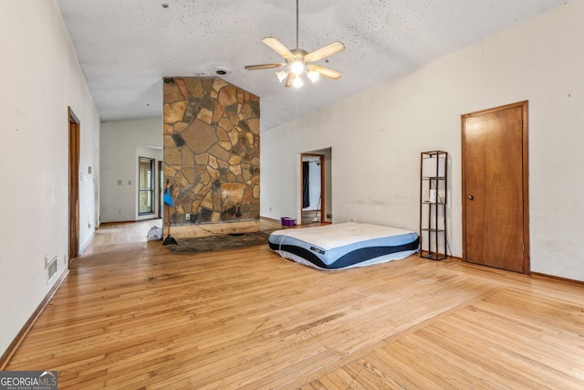 bedroom featuring high vaulted ceiling, a textured ceiling, visible vents, wood finished floors, and baseboards