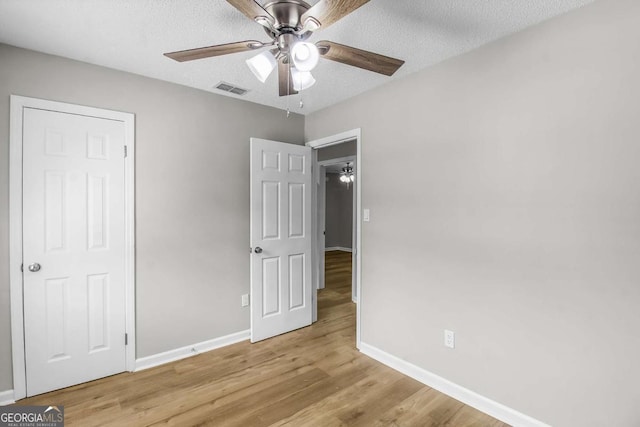 197 Sequoia Cir, Hinesville, GA 31313 - unfurnished bedroom with light wood-style floors, a textured ceiling, and a ceiling fan