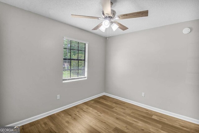 197 Sequoia Cir, Hinesville, GA 31313 - empty room with wood finished floors, a ceiling fan, a textured ceiling, and a smoke detector