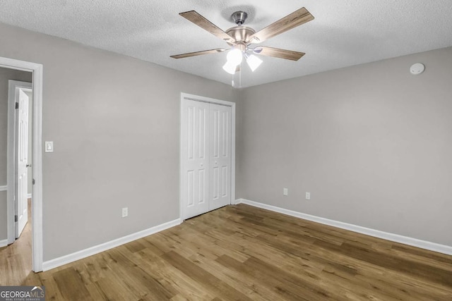 197 Sequoia Cir, Hinesville, GA 31313 - unfurnished bedroom featuring wood finished floors, a closet, ceiling fan, and a textured ceiling