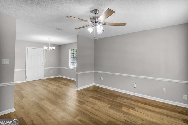 197 Sequoia Cir, Hinesville, GA 31313 - spare room with a chandelier, wood finished floors, a ceiling fan, and a textured ceiling
