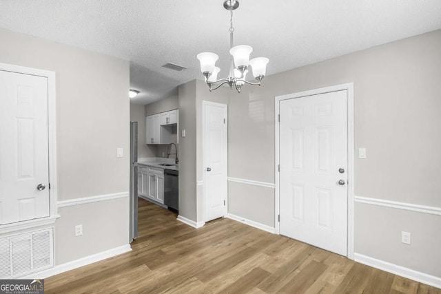197 Sequoia Cir, Hinesville, GA 31313 - unfurnished dining area with a chandelier, wood finished floors, and a textured ceiling