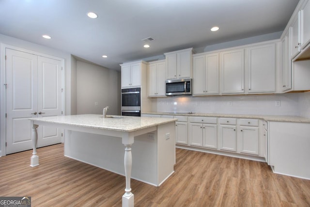 kitchen featuring a sink, visible vents, light wood finished floors, and stainless steel appliances
