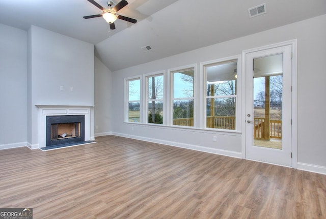 unfurnished living room with light wood finished floors, visible vents, a ceiling fan, and a healthy amount of sunlight
