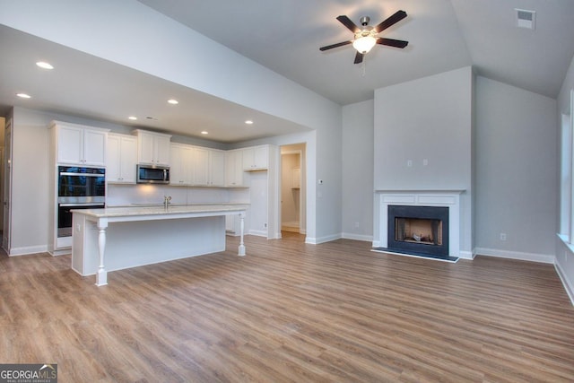 kitchen featuring light wood-style flooring, white cabinetry, and appliances with stainless steel finishes