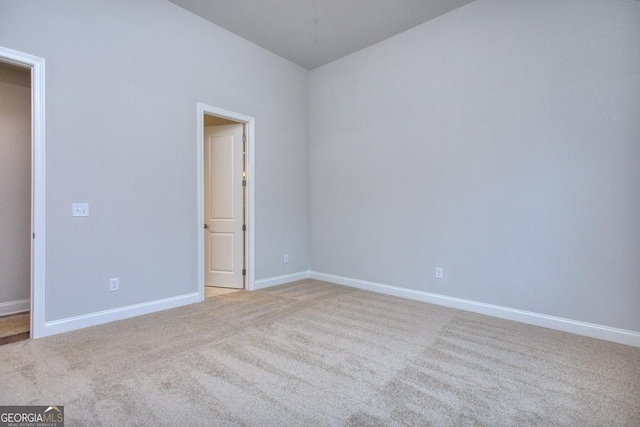 unfurnished bedroom featuring light colored carpet and baseboards