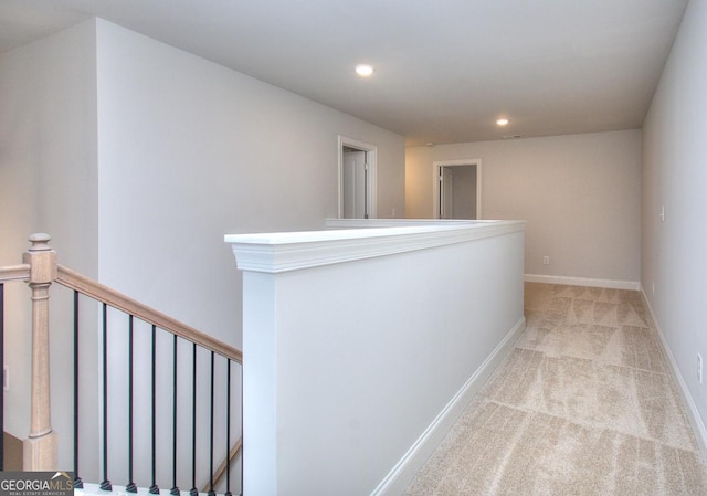 hallway with baseboards, an upstairs landing, light colored carpet, and recessed lighting