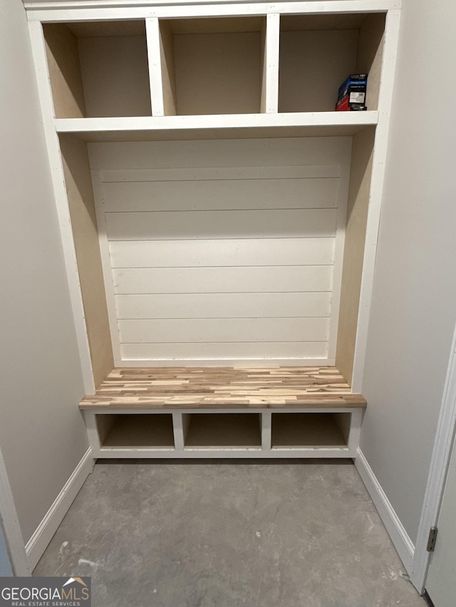 mudroom with baseboards and unfinished concrete flooring