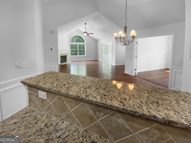 409 Kenley Ct, Mcdonough, GA 30253 - kitchen featuring a ceiling fan, wainscoting, a decorative wall, a fireplace with flush hearth, and a chandelier