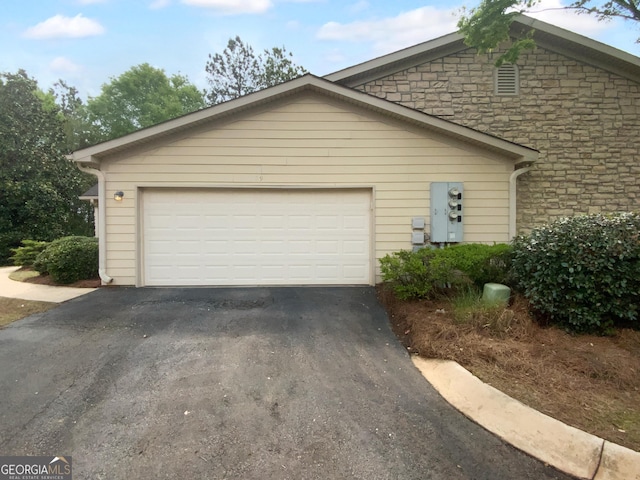 409 Kenley Ct, Mcdonough, GA 30253 - view of front facade featuring asphalt driveway, stone siding, and an attached garage