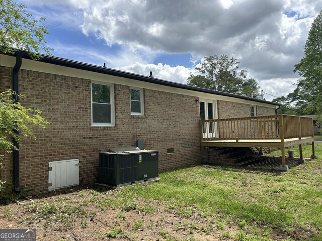 219 Hammerhawk Rd, Griffin, GA 30223 - rear view of house featuring brick siding, a yard, central AC unit, and a deck