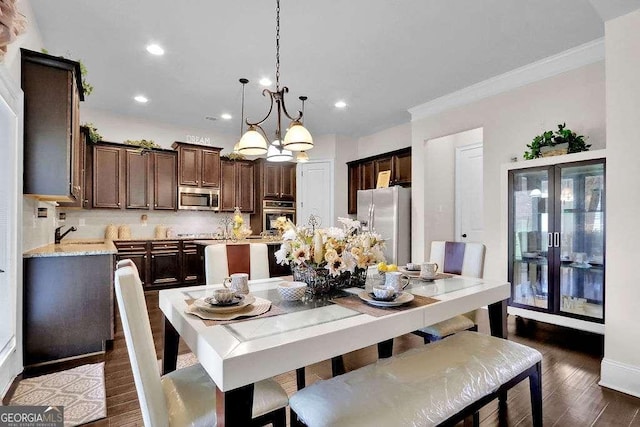 dining room featuring crown molding, dark wood-style flooring, an inviting chandelier, and recessed lighting