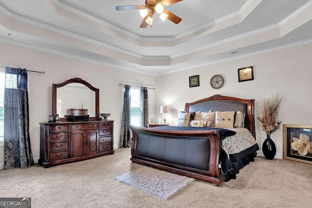 carpeted bedroom featuring visible vents, ceiling fan, ornamental molding, and a raised ceiling