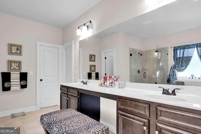 full bathroom featuring double vanity, baseboards, a sink, and a stall shower