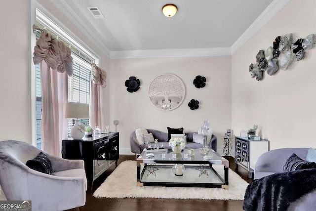 living area with visible vents, baseboards, ornamental molding, and wood finished floors