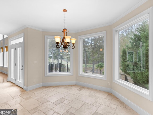 5297 Heron Bay Blvd, Locust Grove, GA 30248 - unfurnished dining area featuring crown molding, an inviting chandelier, baseboards, and stone tile flooring