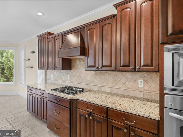 5297 Heron Bay Blvd, Locust Grove, GA 30248 - kitchen featuring premium range hood, appliances with stainless steel finishes, crown molding, and light stone countertops