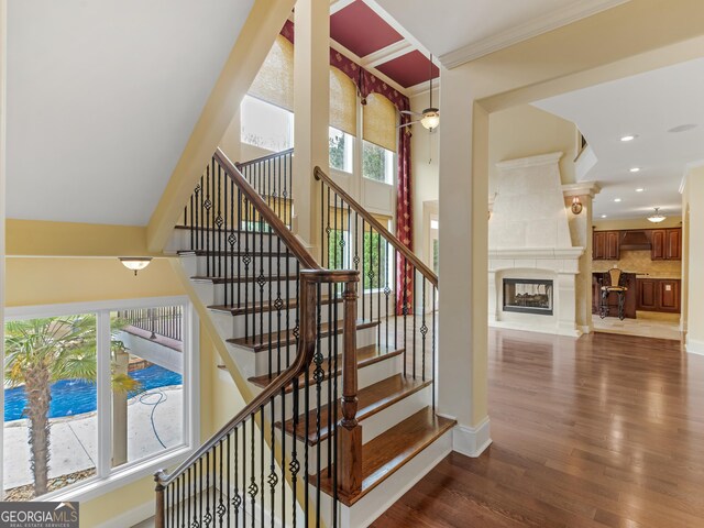 5297 Heron Bay Blvd, Locust Grove, GA 30248 - stairway with wood finished floors, ornamental molding, a glass covered fireplace, and plenty of natural light