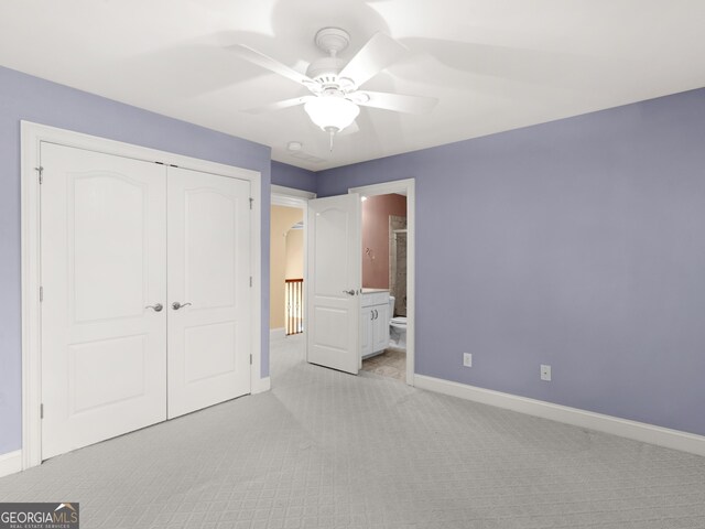 5297 Heron Bay Blvd, Locust Grove, GA 30248 - unfurnished bedroom with a closet, baseboards, ensuite bath, and light carpet