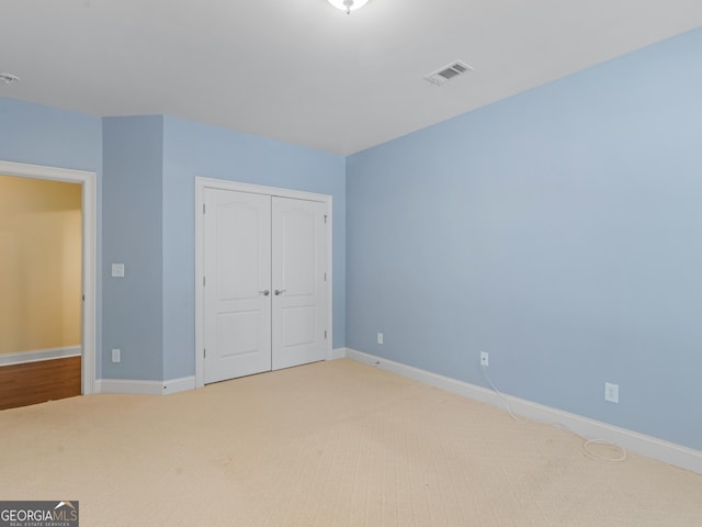 5297 Heron Bay Blvd, Locust Grove, GA 30248 - unfurnished bedroom featuring a closet, baseboards, carpet, and visible vents