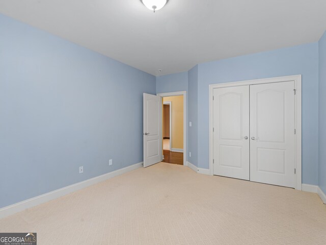 5297 Heron Bay Blvd, Locust Grove, GA 30248 - unfurnished bedroom featuring light carpet, a closet, and baseboards