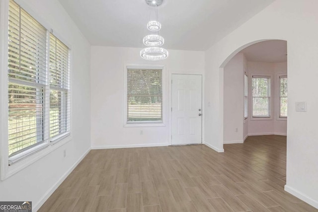 4066 Wild Orchid Ln, Loganville, GA 30052 - interior space with arched walkways, baseboards, an inviting chandelier, and wood finished floors